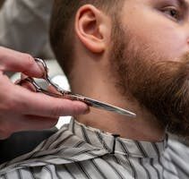 Detailed shot of a barber trimming a man